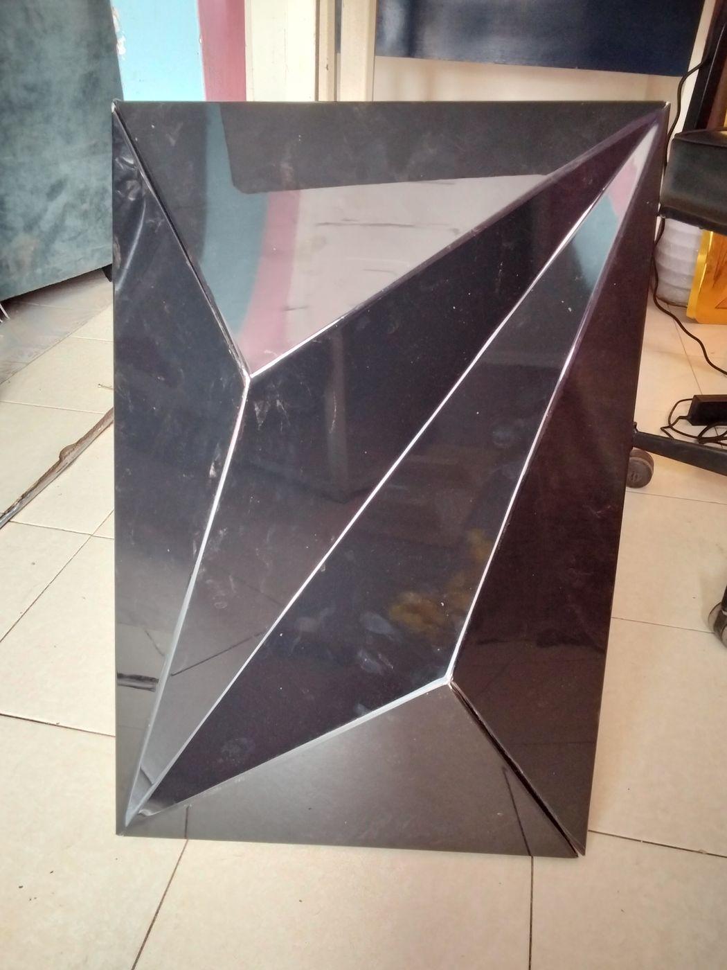 Black ACP panel V-grooved and folded into a faceted 3D shape