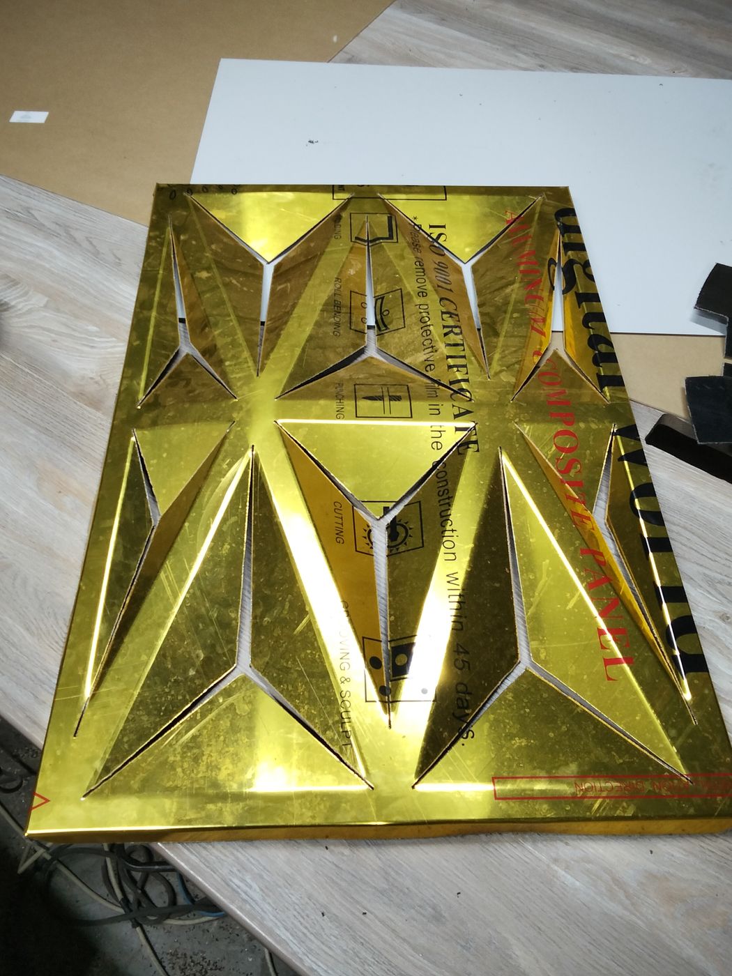 Gold Alucobond (ACP) 3D panel, CNC-cut, V-grooved and folded, with the protective film still on