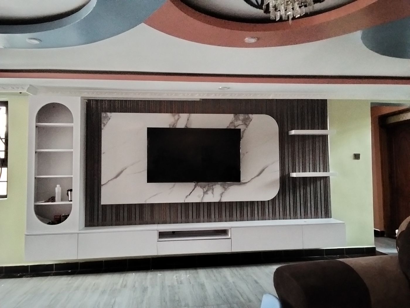 Living-room TV wall panel design with marble-look centre panel, shelving and TV stand