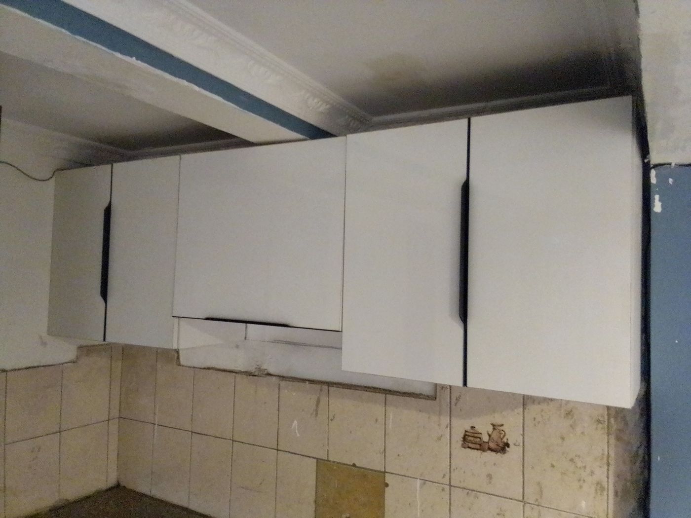 White kitchen wall cabinets during installation